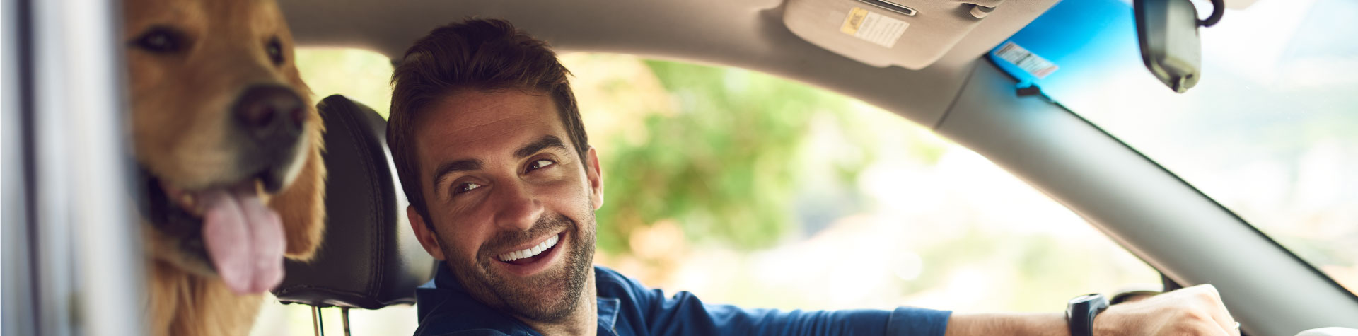 man_in_car_with_dog_smiling